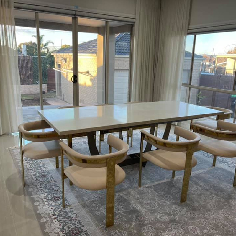 Dining table with a pale stone top and upholstered chairs